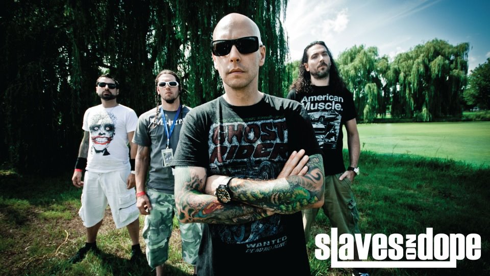 A group of men with tattoos standing in a field.