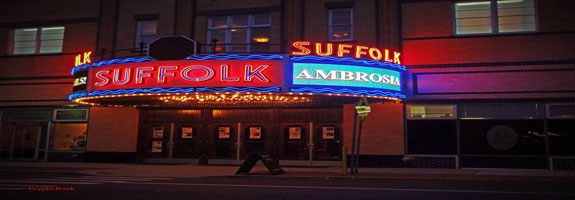 The suffolk theatre is lit up with neon lights.