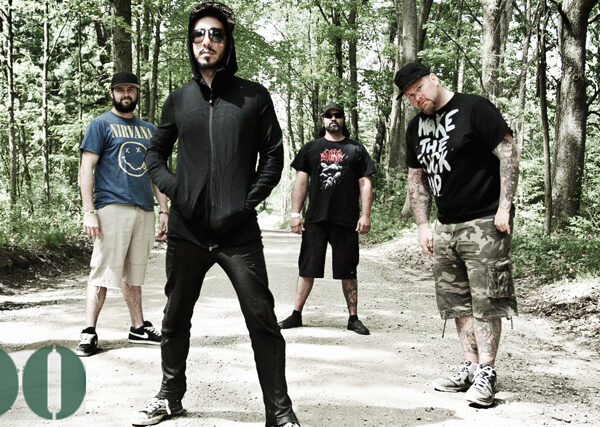 A group of men standing on a dirt road in the woods.