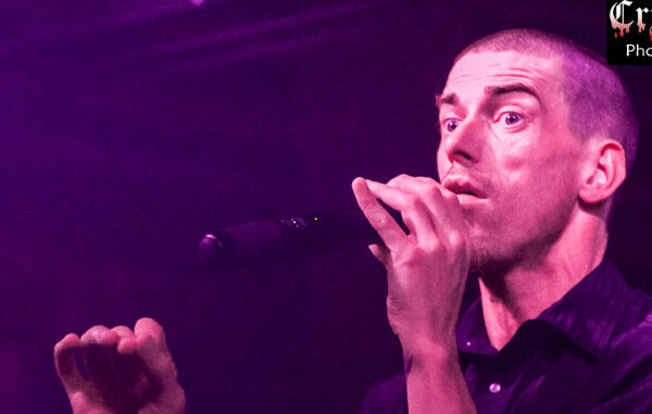 A man singing into a microphone at a concert.