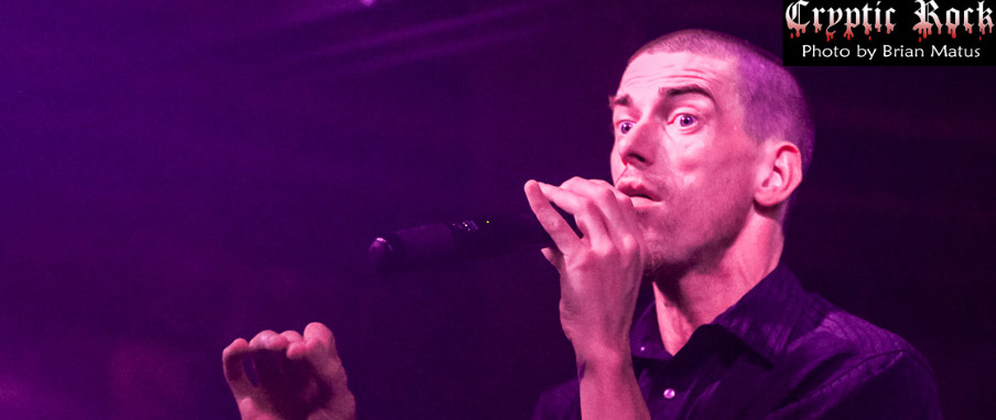 A man singing into a microphone at a concert.