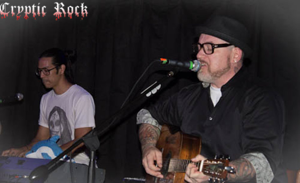 A group of men playing guitar and singing in front of a microphone.