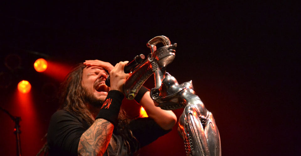 A man with dreadlocks singing on stage.