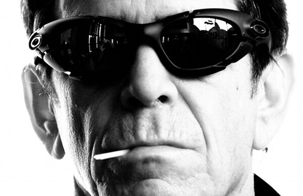 A man in sunglasses smoking a cigarette.