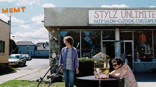 Two people standing in front of a store with a sign that says styz unlimited.