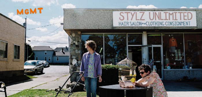 Two people standing in front of a store with a sign that says styz unlimited.