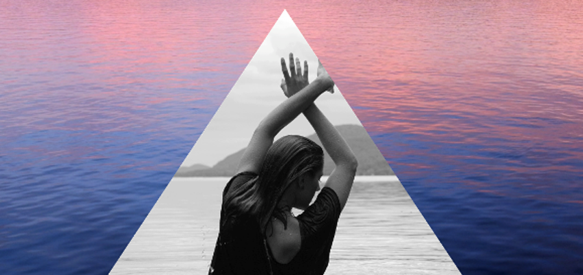 A triangle with a woman's hands out in front of a body of water.