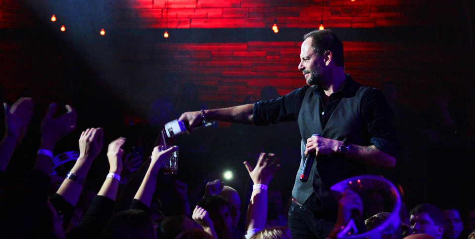 A man with a microphone in front of a crowd.