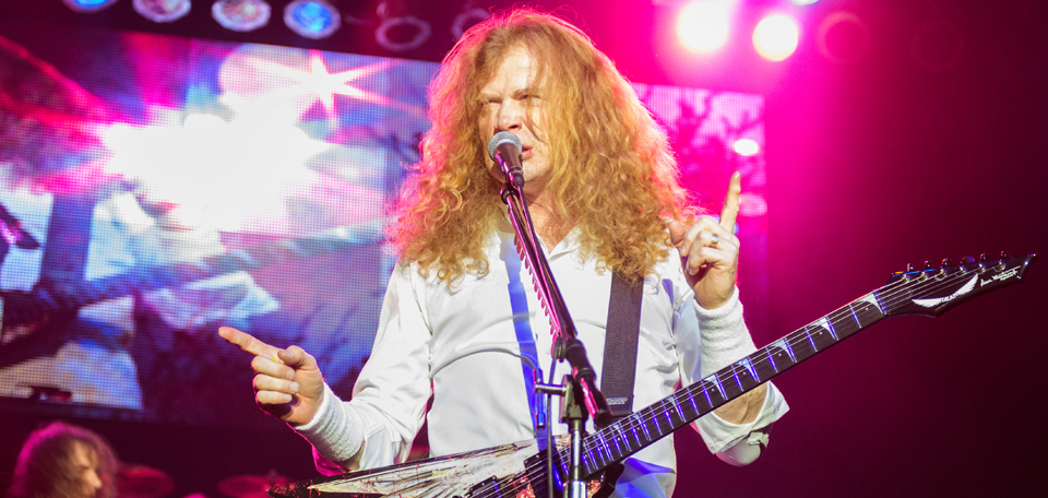 A man with long hair playing an electric guitar.