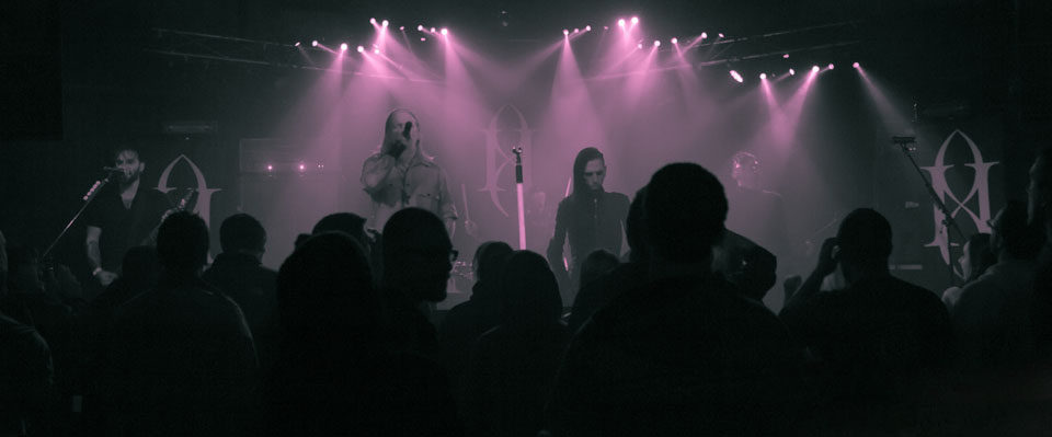 A group of people on stage in a dark room.
