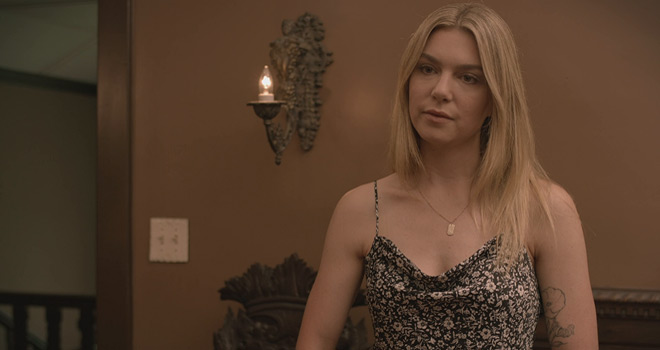 A woman in a floral dress standing in a room.